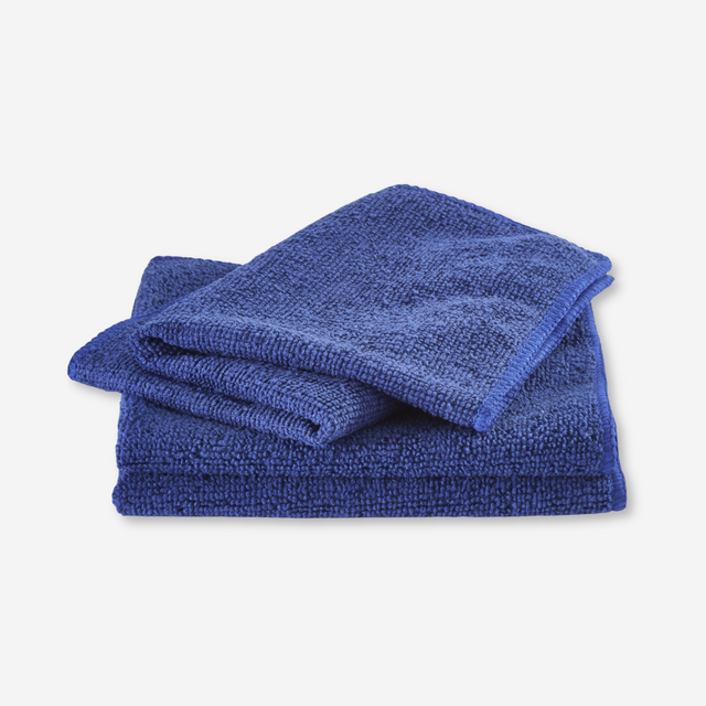 Blue microfiber dishcloth folded on a white background.