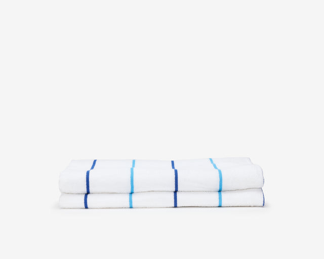 Folded pool towel, white with small dark blue and light blue stripes.