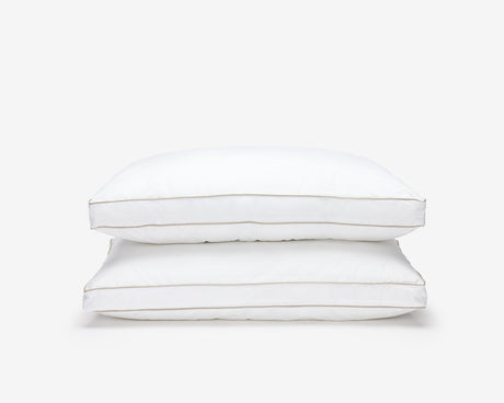 Two white O'zenith pillow, one on top of the others.