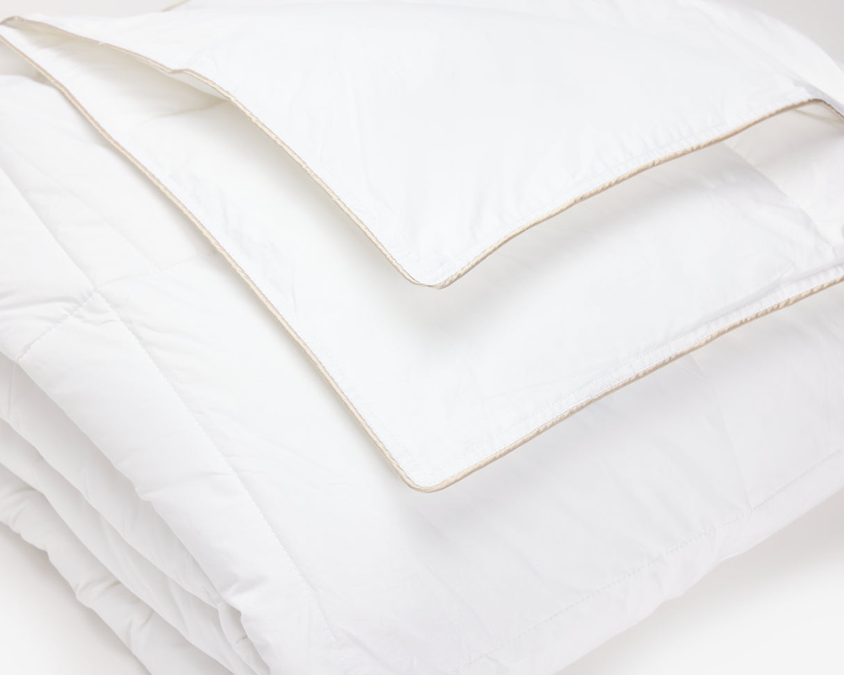 Close up picture of a white hotel duvet folded.