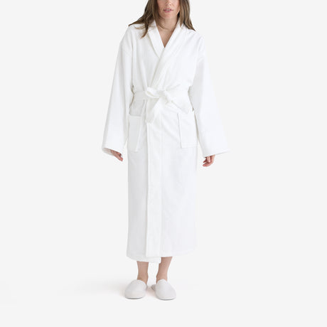 White elegant hotel bathrobe worn by a women also wearing white hotel slippers