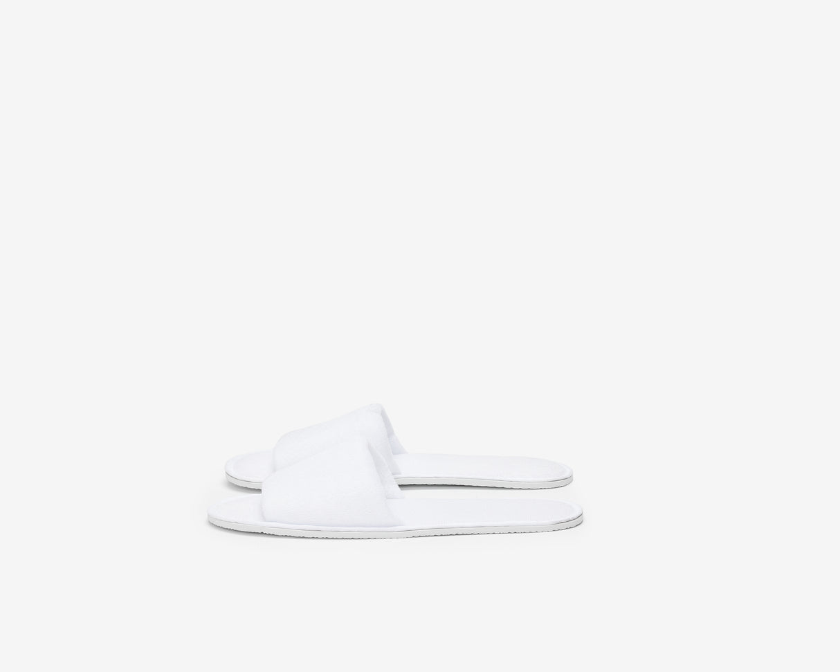White hotel open toe slippers view from the side.