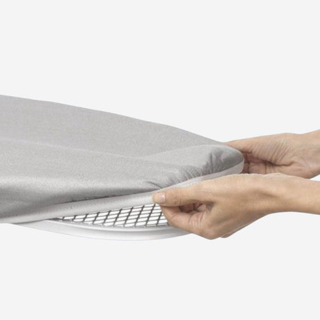 Grey ironing board cover being installed on an ironing board
