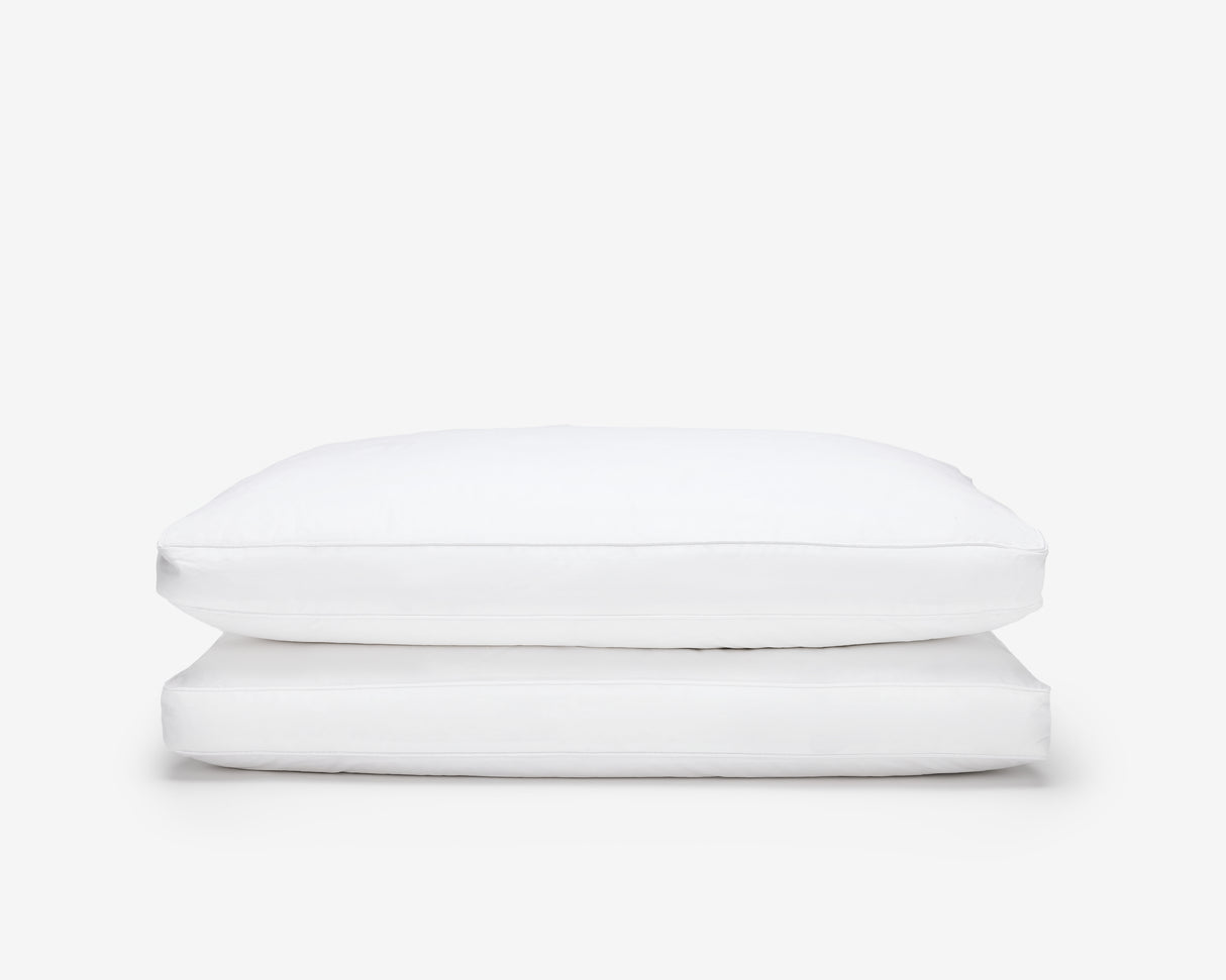two white hotel box pillow, one on top of the other on a white background