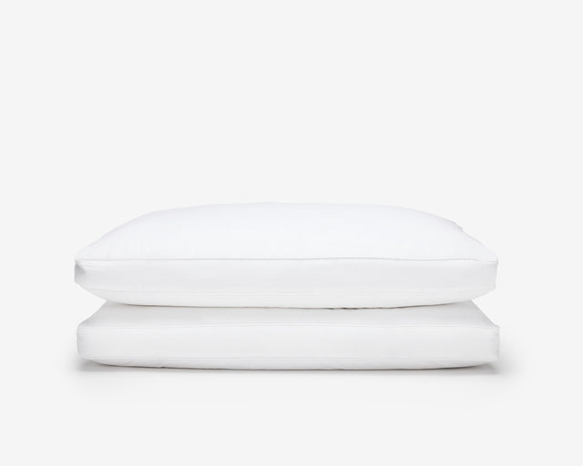 two white hotel box pillow, one on top of the other on a white background