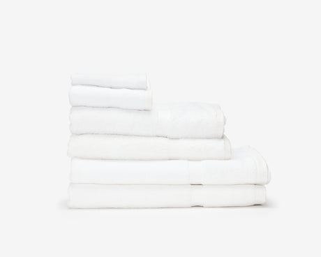 Folded white hotel towels placed on top of each other to form a pile.
