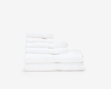 Pile of white hotel towels of different sizes.