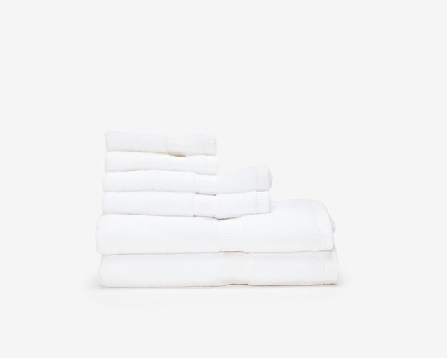 Pile of white hotel towels of different sizes.