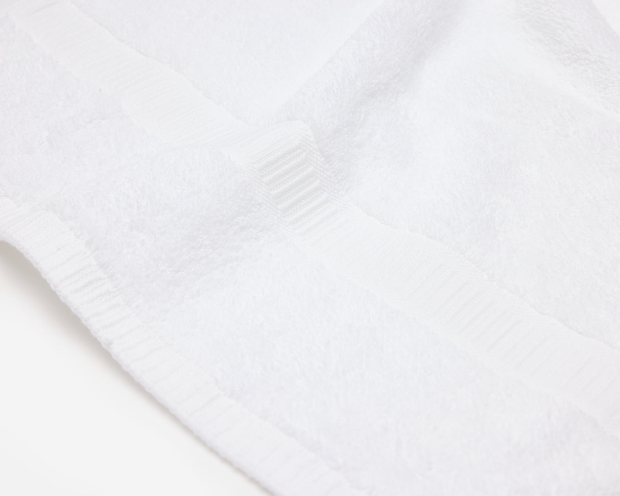 Close up picture of a white hotel towel with an elegant dobby border.