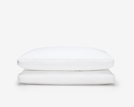 two white hotel box pillow, one on top of the other on a white background 